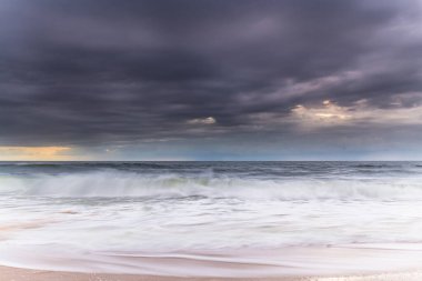 Central Coast, NSW, Avustralya 'daki MacMasters Sahili' nden kasvetli bir gündoğumu deniz manzarası..