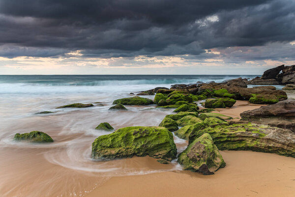 Санрайз и зеленые камни на пляже Киллкэр на Центральном побережье штата Новый Южный Уэльс, Австралия
.