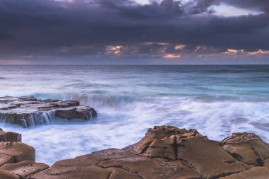 Central Coast, NSW, Avustralya 'daki Kuzey Avoca Sahili' nden bulutlu gün doğumu.
