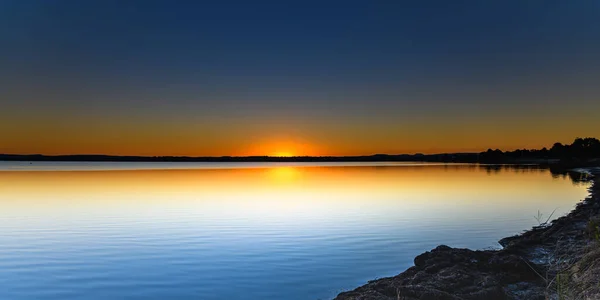 Avustralya, NSW 'nin merkez kıyısındaki Canton Sahili' nden Tuggerah Gölü üzerinde gün batımı.