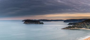 Kırık Koyun üzerindeki günbatımı deniz manzarası Avustralya 'nın NSW merkez sahilinde Ettalong Dağı' ndan Pearl Sahili 'ne kadar uzanan Aslan Adası ve Barrenjoey Burnu' na bakıyor.