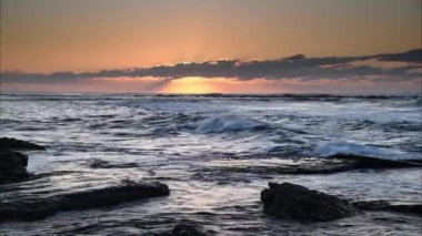 Sahilde gün doğumu. Kayalık bir kıyı şeridi ve Avustralya 'nın merkez kıyısındaki Toowoon Körfezi Sahili' nden güneş ışınları..