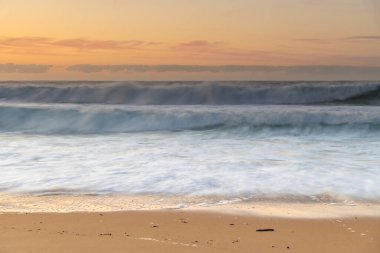 Deniz kenarında kış sabahı, dalgalar ve hafif bir ışık bulutu Central Coast, NSW, Avustralya 'daki Killcare Sahili' nde..