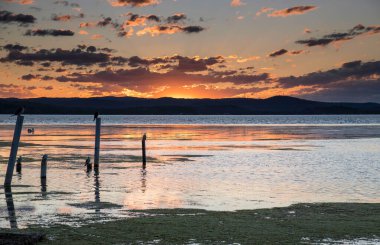 Günbatımı ve bulutlar Avustralya, NSW 'nin merkez kıyısında Long Jetty üzerinde.