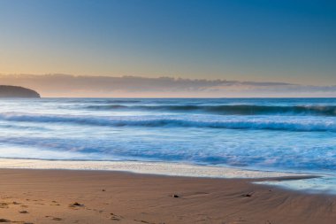 Gündoğumu deniz manzarası yeni taşlarla örtüldü ve kumsaldaki erozyondan sonra Central Coast, NSW, Avustralya 'daki Killcare Sahili' nde yer değiştirdi..
