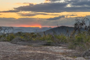 Avustralya, NSW 'nin merkez kıyısında, Patonga ve Pearl Beach arasındaki Bouddi Ulusal Parkı' nda Tessellated Rock Pavement ile çalılıklarda gün batımı..