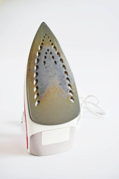Dirty surface Iron for ironing things on a white isolated background. Concept breakdown or problem, laundry, sewing studio, housework