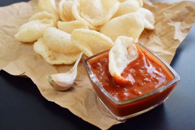 Kağıt üzerinde karides kraker ya da ketçaplı karides cipsi, koyu arkaplanda taze Krupuk..