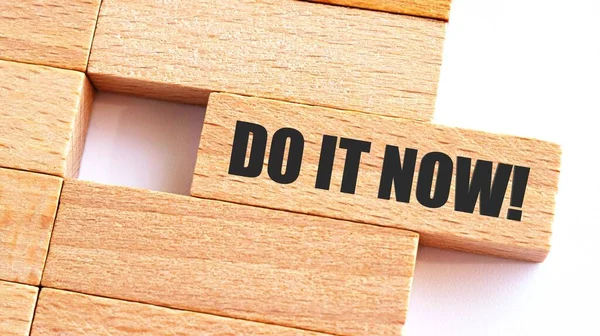 do it now written on wood blocks. Business concept.A piece of wood with text do it now.