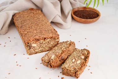 Açık gri mermer arka planda ahşap bir tahtada fındık ve keten tohumlu ev yapımı ekmek. Diyet ve sağlık için yiyecek. Sağlıklı badem ekmeği, Keto, ketojenik diyet, paleo, düşük karbonhidratlı, glütensiz.