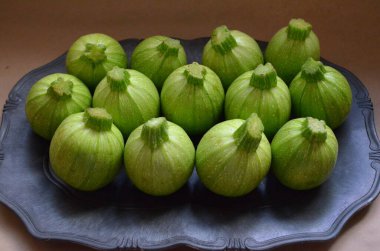 Koyu gri bir tabakta sevimli yuvarlak organik kabak. 