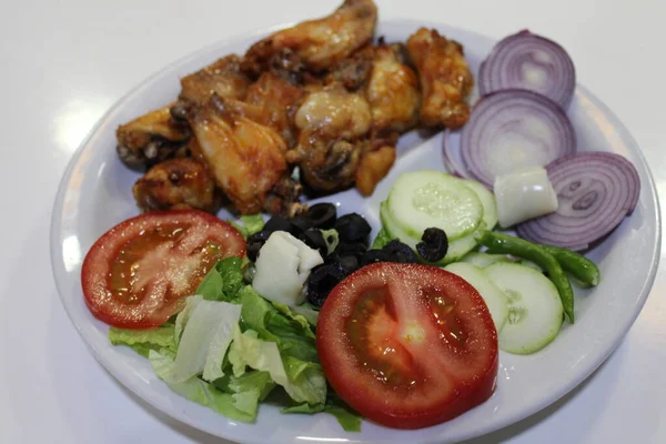 Yemek masasında salatalı kızarmış tavuk.