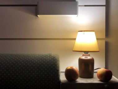 Masa lambası, kahve fincanı ve yatak odası masanın üstünde.