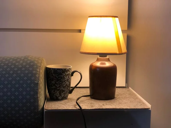 lightening Table lamp with coffee mug with the bed in bedroom on the table