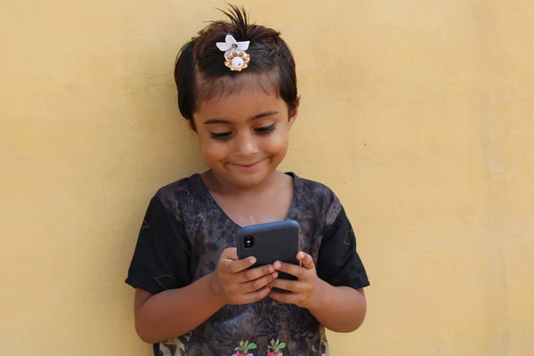 cute asian kid watching mobile phone with smile