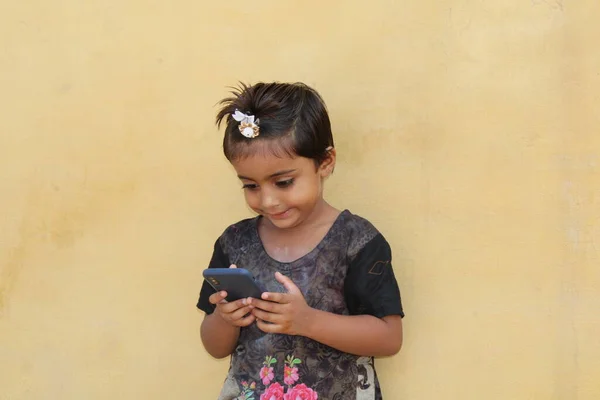 cute asian kid watching mobile phone with smile