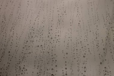  Pencerede yağmur damlaları ve gri bulutlar