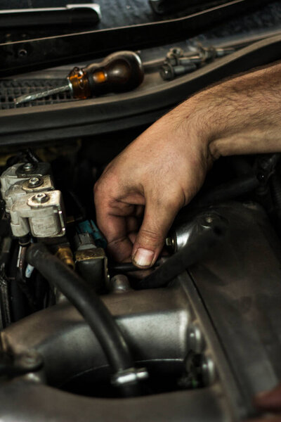 Автомеханик, работающий над запчастями для автомобиля
