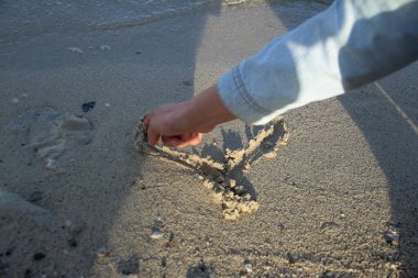 Kumdan kalbe parmak çek.