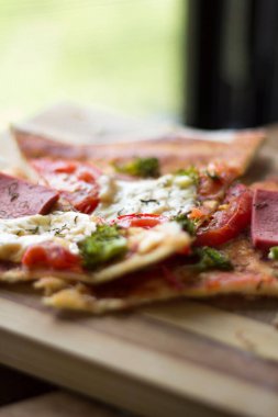 Jambonlu pizza, domates peyniri ve brokoli.