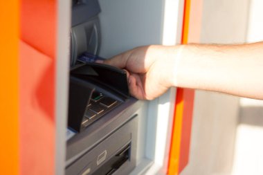 Erkek eli ATM 'ye kredi kartı sokar.