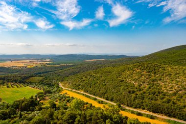 Capalbio Kalesi, Toskana, İtalya 'dan manzara, tarlaları, tepeleri, binaları, mavi gökyüzü ve bulutlarıyla