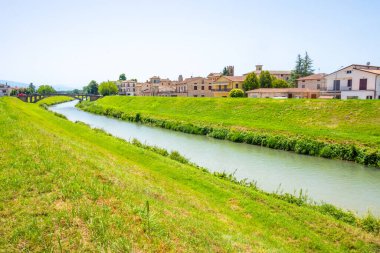 La campagna intorno al piccolo borgo antico di Cannara in provincia di Perugia, Umbria, Italia con il fiume Topino e campi coltivati