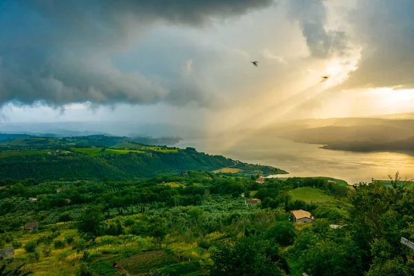 Un raggio di sole diretto verso l 'acqua durante un tramonto coloratissimo e scenografico sul lago di Corbara, Umbria, Italia