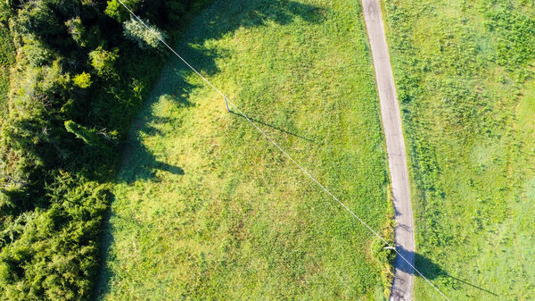 Aerial view of a road in italian countryside among meadows and woods