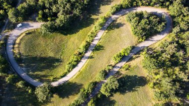 Yollar, çayırlar ve ağaçlarla çizilmiş İtalyan kırsalının havadan görünüşü