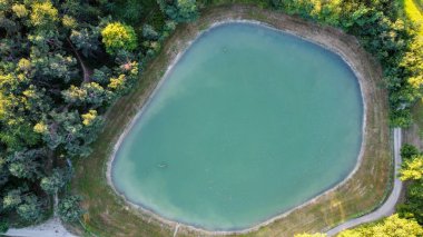 İtalyan Appennini tepelerindeki küçük bir göl ve ağaçların havadan görünüşü.