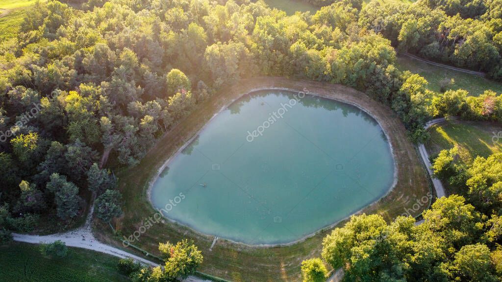 Aerial view of a little lake and trees surrounding, in italian Appennini hills
