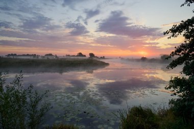 Gölün üzerinde puslu şafak.
