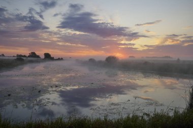 Gölün üzerinde puslu şafak.