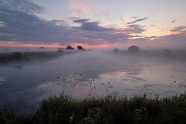 Gölün üzerinde puslu şafak.