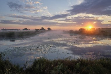Gölün üzerinde puslu şafak.