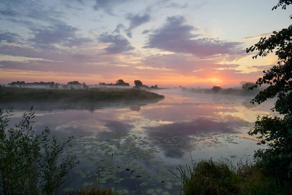 Gölün üzerinde puslu şafak.