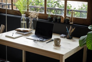 Modern ev ofisinin yaratıcı alanı, masa başında dizüstü bilgisayar, oturma odasında kanepe, Coronavirus sırasındaki karantina izolasyonu (COVID-19) sağlık krizi sırasında ev hayatı tarzında çalışmak için mükemmeldir.