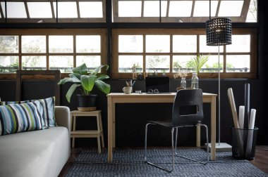 Modern ev ofisinin yaratıcı alanı, masa başında dizüstü bilgisayar, oturma odasında kanepe, Coronavirus sırasındaki karantina izolasyonu (COVID-19) sağlık krizi sırasında ev hayatı tarzında çalışmak için mükemmeldir.