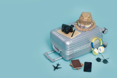 Pasaport, kamera, şapka, cüzdan, uçak oyuncağı ve akıllı telefon ile seyahat bagajı kopya alanı, seyahat konsepti arka planı ile mavi arka planda izole