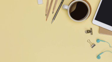 Üst görünüm çalışma alanı ofis malzemeleri tablet, sıcak kahve fincanı, sarı arka planda izole edilmiş kitap ve aksesuarlar, fotokopi alanı ile genel görünüm, tasarımcı konsepti için çalışma alanı