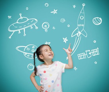Asyalı kız çocuğu hayal gücüyle tahtaya işaret ediyor astronot ve uzay roketi, yaratıcı ve çocukluk konsepti hayalleri.