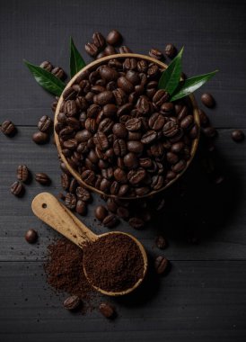 Kahve çekirdekleri ve ahşap masanın üzerindeki kahve tozu.