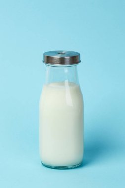 Mavi zemin üzerinde taze süt şişesi