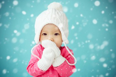 Beyaz kaniş şapkalı bebek ve kar yağan eldivenli örgü