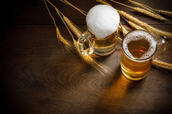 Glasses of Light Beer with wheat on the wooden table, copy space for your text