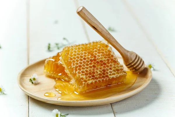 Beyaz ahşap arka plan, organik gıdalar ve sağlıklı konsept üzerine derili bal petekleri.
