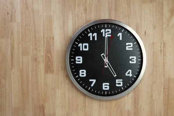 木製の壁の背景に5時位置にステンレス製の時計 時間の概念でビジネス ロイヤリティフリーのストック写真