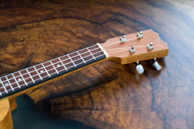 Bir ukulele fretboard yakın çekim - küçük açık kahverengi enstrüman güzel ahşap masa üzerinde.