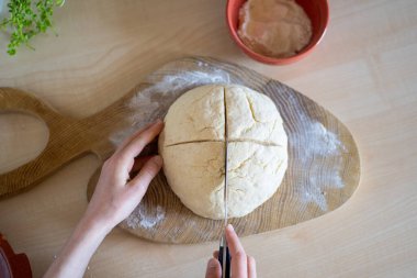Çocuk hamur yapıyor ve hazırlanması kolay ve sağlıklı, ev yapımı İrlanda sodası ekmeği kesiyor..